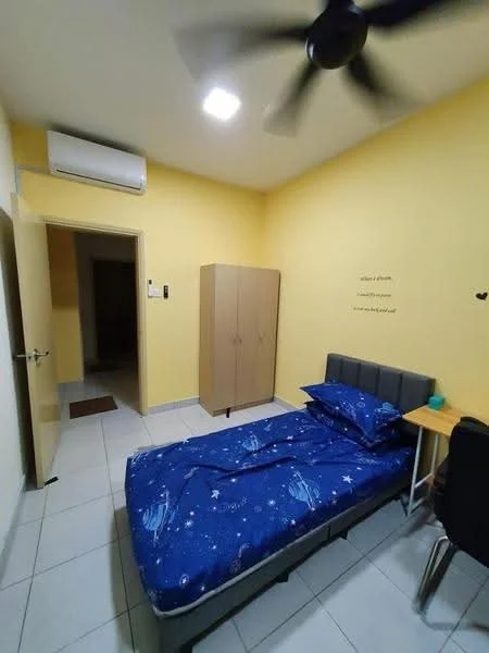 Bedroom features: single bed with blue bedding featuring star pattern, grey upholstered headboard, wooden wardrobe in light brown, study desk with black chair, white walls, ceiling fan with 5 blades, wall-mounted air conditioning unit, tile flooring, window with no visible treatment, decorative wall text; style: modern.