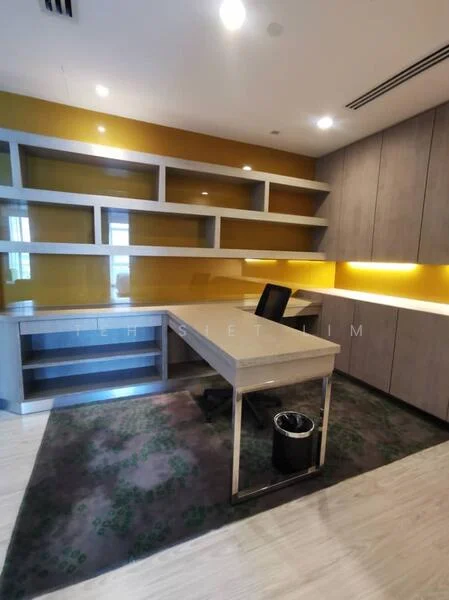 Study features: built-in shelving units, grey cabinetry, yellow accent wall, wooden flooring, desk with metal frame, black office chair, recessed LED downlights, decorative area rug with green pattern, waste bin; style: modern.