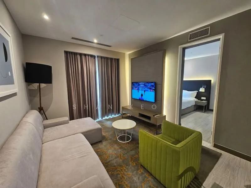 Living features: L-shape sectional sofa in light grey, green accent chair, round white coffee table, wall-mounted TV, TV console, area rug with geometric pattern, floor-to-ceiling windows with sheer curtains, recessed downlights, decorative wall panel, wooden flooring; style: modern. Room features: doorway leading to bedroom, grey painted walls.