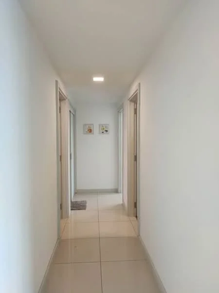 Hallway features: white painted walls, tile flooring, recessed downlights, two doorways on either side, decorative artwork on walls, neutral color scheme, clean lines, spacious layout; style: modern.