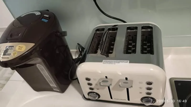 Room features: toaster, 4-slice toaster in white, electric kettle in black, countertop, kitchen appliances.