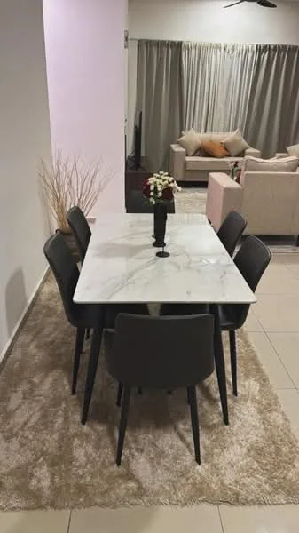 Dining features: marble dining table, 6 black dining chairs, area rug with beige color, decorative vase with flowers, neutral wall color, large window with sheer curtains, ceiling fan, tile flooring; style: modern. Living features: beige sectional sofa, decorative cushions, coffee table, TV console, large window with curtains; style: modern.