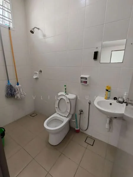 Bathroom features: white tiled walls, light beige floor tiles, one-piece toilet, handheld shower, wall-mounted sink, toilet paper holder, mop and broom hanging, small mirror, soap dispenser.