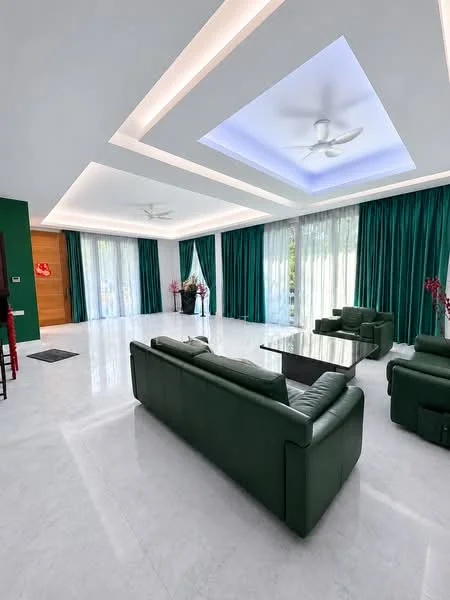 Living features: green leather sofa, glass coffee table, marble flooring, tray ceiling with recessed lighting, ceiling fan, floor-to-ceiling windows, sheer curtains, dark green drapes, decorative plants in vases, wall-mounted artwork, open layout, natural light; style: modern; view: garden.