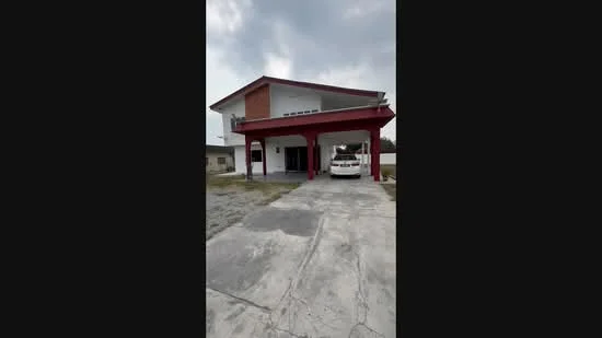 Exterior type: detached bungalow; features: red painted facade, flat roof, single-storey, car porch with awning, driveway with concrete paving, manicured lawn, surrounded by open space; style: modern.