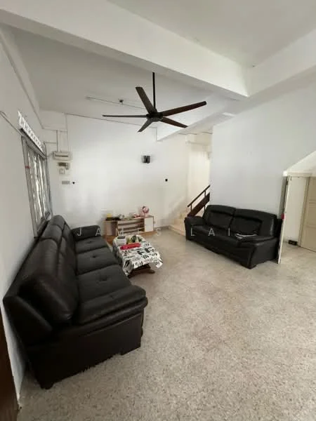 Living features: 3-seater leather sofa in black, 2-seater leather sofa in black, coffee table, ceiling fan, wall-mounted air conditioning unit, light-colored terrazzo flooring, white painted walls, staircase in background, decorative throw blanket on sofa; style: modern.