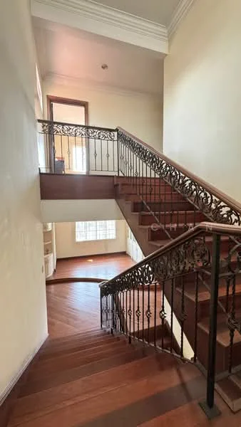 Staircase features: wooden staircase, iron railing with decorative pattern, cream painted walls, natural light from windows, hardwood flooring, crown moulding at ceiling; style: traditional.