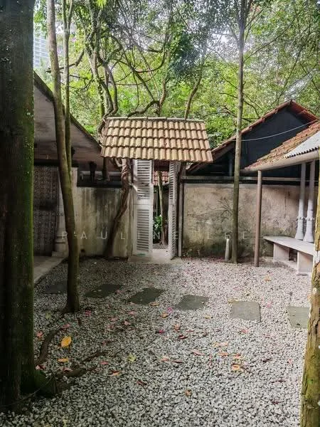 Exterior type: landscape garden; features: gravel pathway, stone pavers, mature trees, thatched roof structure, surrounding greenery, outdoor seating area, decorative stone, fenced perimeter; style: tropical-modern.