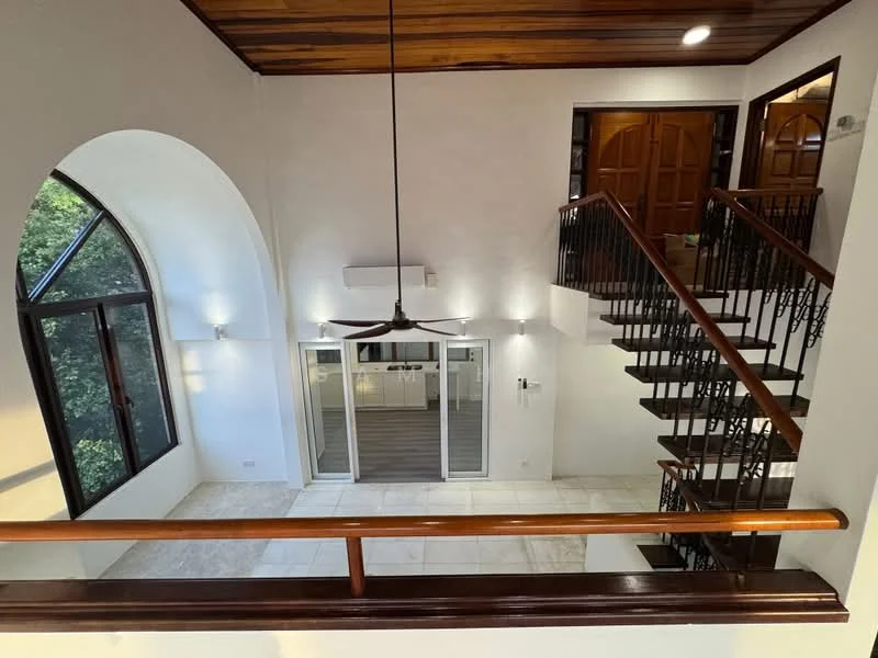 Room features: arched windows, wooden ceiling, white painted walls, marble tile flooring, black wrought iron railing, ceiling fan, split air conditioning unit, double wooden doors, recessed lighting; style: modern; view: garden.