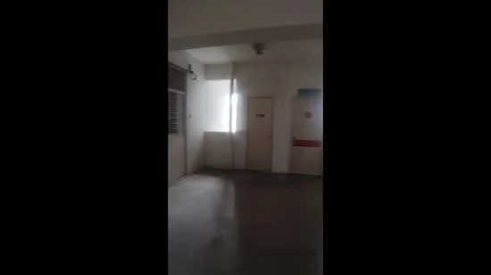 Room features: white painted walls, concrete flooring, single door, window with natural light, ceiling light fixture.