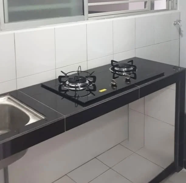 Kitchen features: black countertop, stainless-steel sink, 2-burner gas hob, white tiled walls, white tiled flooring, window for natural light, metal faucet, open shelving below countertop; style: modern.