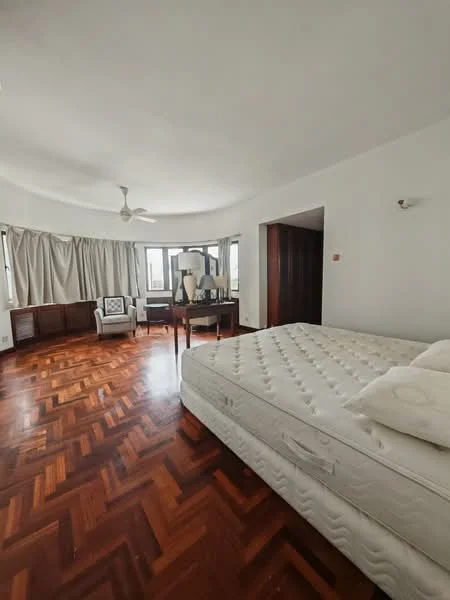 Bedroom features: wooden flooring, white painted walls, ceiling fan, large windows, curtains, queen-size bed, upholstered headboard, side table, armchair, decorative lamp, built-in wardrobe; style: minimalist.