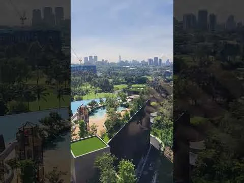 Exterior type: high-rise condominium; features: infinity pool, landscaped garden, children's playground, manicured lawn, surrounded by mature greenery, city skyline view, outdoor dining area, pool deck with loungers; style: modern.