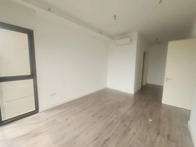 Room features: light wood laminate flooring, white painted walls, 1 wall-mounted split AC, floor-to-ceiling window, sliding glass door, neutral ceiling, recessed downlights, plain door; style: modern.