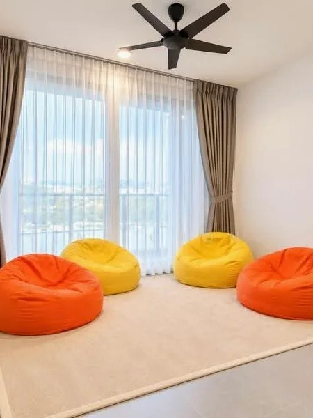 Room features: 4 bean bag chairs in orange and yellow, light grey area rug, floor-to-ceiling windows, sheer curtains, drapes, ceiling fan with 3 blades, neutral painted walls, tile flooring; style: modern; view: city.