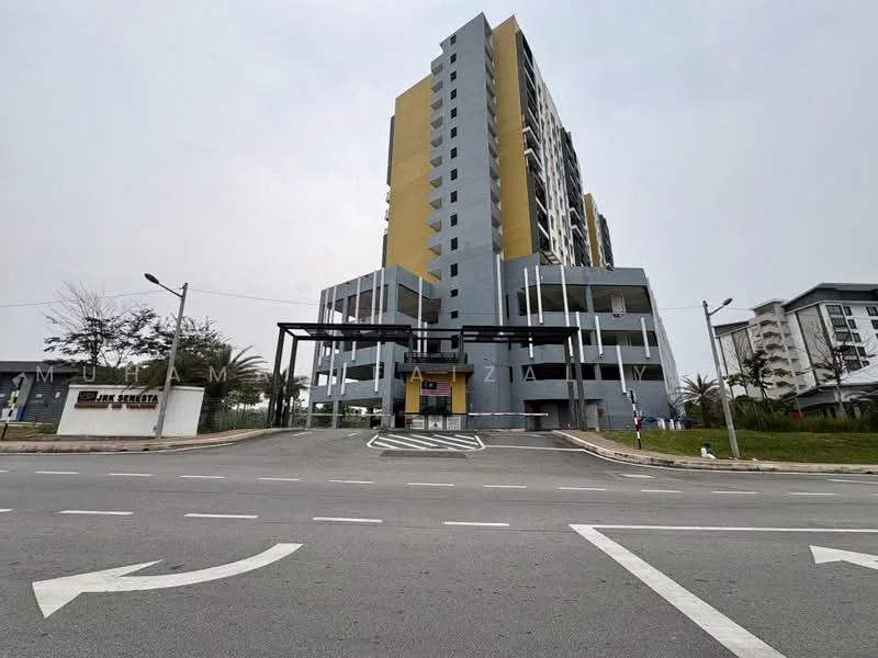 Exterior type: high-rise condominium; features: grey painted facade, yellow accent panels, multiple storeys, covered parking area, entrance with signage, surrounded by greenery, paved driveway, street lighting, sidewalk, landscaped area; style: modern.