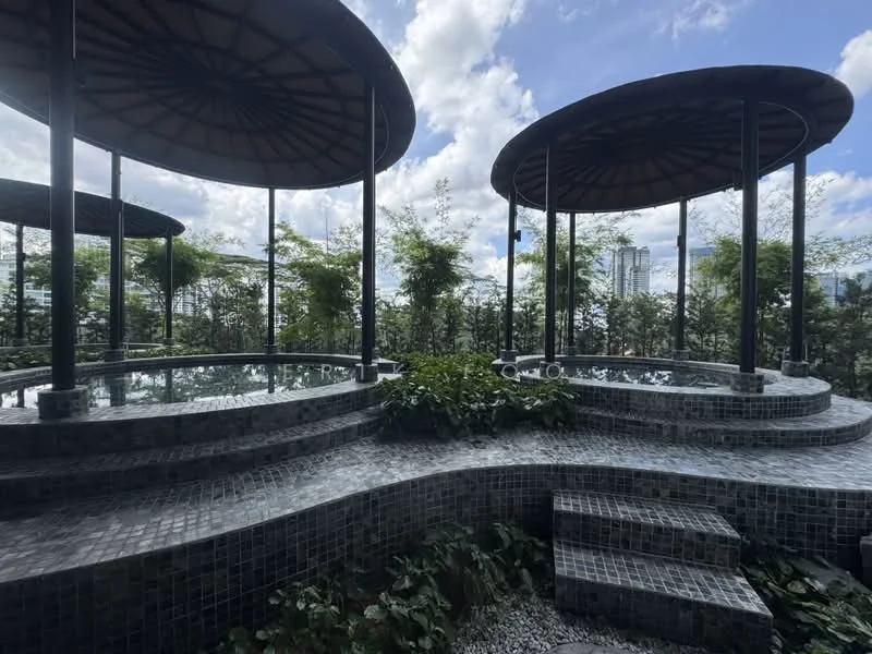 Exterior type: landscape garden; features: three circular pavilions with thatched roofs, stone seating areas, decorative mosaic tile flooring, lush greenery surrounding the area, planters with various plants, open sky with scattered clouds, urban skyline visible in the background; style: modern.