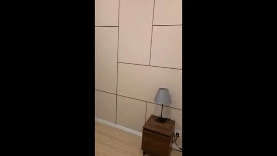 Room features: light wood flooring, beige painted walls with paneling, table lamp with grey shade, wooden nightstand, electrical outlet visible; style: modern.