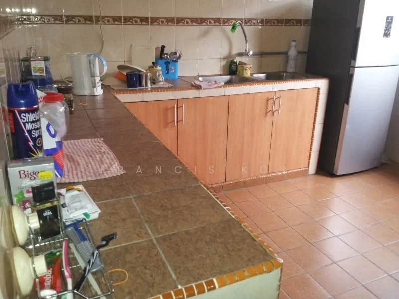 Kitchen features: brown tiled countertop, wood cabinetry, stainless-steel sink, chrome faucet, ceramic tile flooring, refrigerator, kettle, various kitchen utensils, dish rack, wall-mounted tiles with decorative border.