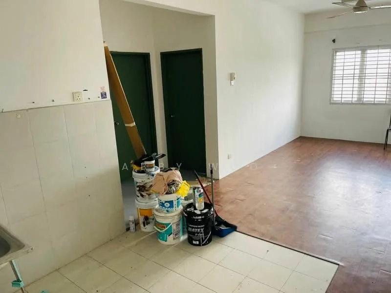 Room features: white painted walls, wooden flooring, ceiling fan, two green doors, kitchen sink, tiles on kitchen wall, buckets of paint, cleaning supplies, chair, window with horizontal slats.