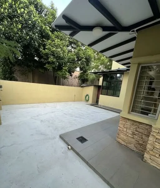 Exterior type: detached bungalow; features: concrete flooring, stone cladding on walls, flat roof with overhang, manicured greenery, fenced perimeter, outdoor space with potential for landscaping, large windows, doorway access to interior; style: modern.
