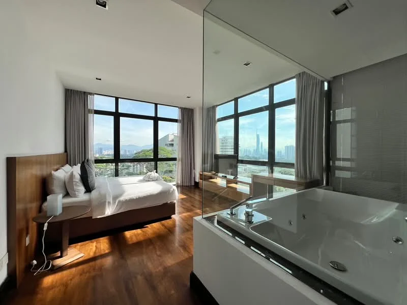 Bedroom features: king-size bed with white bedding, wooden bed frame, floor-to-ceiling windows, grey curtains, wooden flooring, nightstand with lamp, view of city skyline, built-in wardrobe, decorative wall art; style: modern; view: city. Bathroom features: freestanding bathtub, glass enclosure, modern faucet, tile cladding, large mirror, natural light from window; style: modern; view: city.