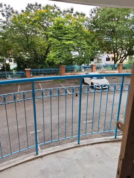 Room features: blue metal railing, concrete flooring, view of parking lot, view of trees, outdoor space, attached balcony; view: garden.