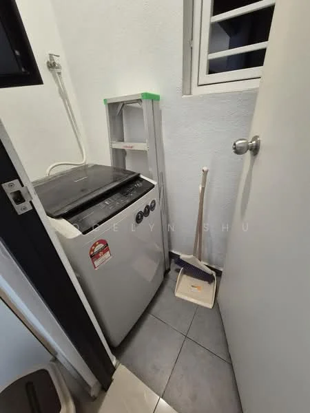 Laundry features: top-load washing machine, grey tiled flooring, white painted walls, window with security bars, cleaning broom, dustpan, laundry area with limited space.