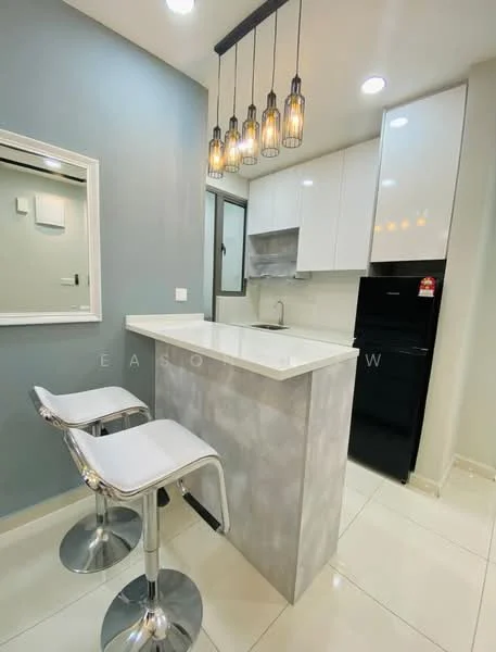Kitchen features: white glossy upper cabinets, grey lower cabinets, white countertop, stainless-steel sink, chrome pull-down faucet, built-in stove, black refrigerator, pendant lighting with glass bulbs, bar counter with two chrome bar stools, white tiled flooring, grey painted accent wall, mirror on wall; style: modern.