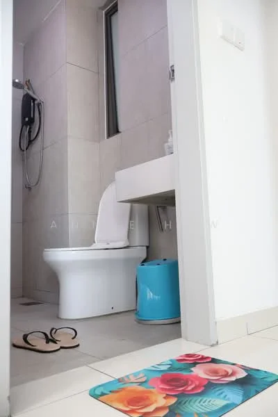 Bathroom features: white toilet, single-sink vanity with white cabinet, mirror above sink, shower with handheld showerhead, light grey tiled walls, light grey tiled flooring, blue trash bin, decorative bath mat with floral pattern, sliding window, wall-mounted shower control, flip-flop sandals on floor; style: modern.