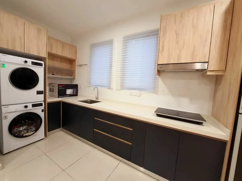 Kitchen features: white quartz countertop, dark blue cabinetry, light wood upper cabinets, built-in microwave, stainless-steel range hood, 4-burner induction hob, single-bowl stainless-steel sink, chrome pull-down faucet, stacked washer and dryer, tile flooring, window with blinds; style: modern.