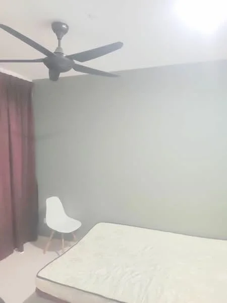 Bedroom features: grey painted walls, 5-blade ceiling fan, single bed mattress, curtains in dark red, light-colored chair with wooden legs, carpeted flooring, no visible storage, no visible decor.