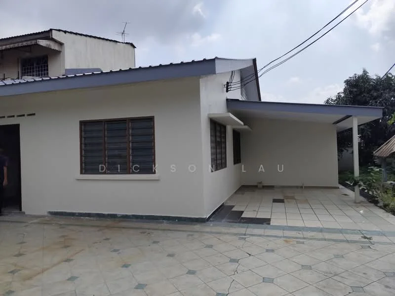Exterior type: detached bungalow; features: white painted facade, flat roof, single-storey, tiled flooring, windows with grilles, covered porch, manicured lawn, surrounded by greenery; style: modern.