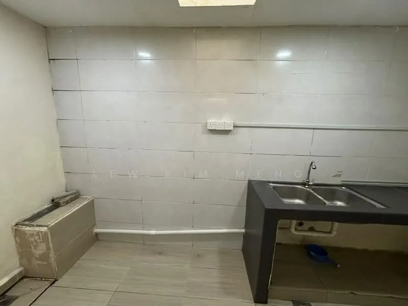 Kitchen features: double-bowl stainless-steel sink, chrome pull-down faucet, grey laminate countertop, white tiled walls, light grey ceramic tile flooring, wall-mounted electrical outlets, plumbing visible, no cabinetry.