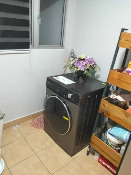 Laundry features: front-load washing machine in black, tile flooring, white painted walls, window with blinds, wooden shelving unit, decorative flowers in vase, storage baskets, cleaning supplies.
