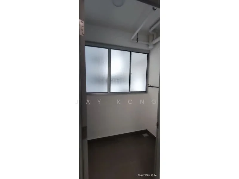 Laundry features: grey tiled flooring, white painted walls, frosted glass window, ceiling-mounted pipes, light fixture, wall-mounted shelf.