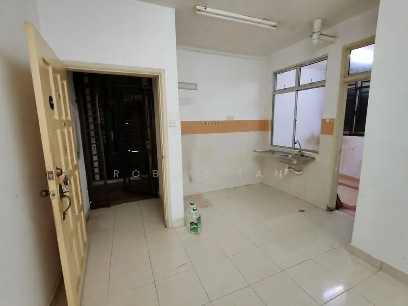 Room features: white painted walls, cream tiled flooring, single-bowl stainless-steel sink, wall-mounted faucet, window with natural light, ceiling light fixture, door leading to another room, empty space, no visible appliances, no visible furniture.