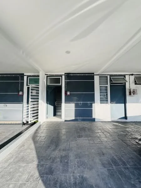 Exterior type: low-rise apartment block; features: grey painted facade, flat roof, ground floor entrance, multiple windows, security grills on windows, textured concrete flooring, staircase access, outdoor lighting, covered walkway; style: modern.