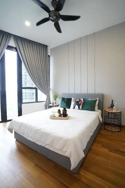 Bedroom features: king-size bed with grey upholstered frame, white bedding, decorative pillows in green and patterned, wooden flooring, floor-to-ceiling windows, black ceiling fan with 5 blades, curtains in grey fabric, side table with black metal frame, decorative items on side table, wall with vertical paneling in light grey, plant in ceramic pot; style: modern; view: city.