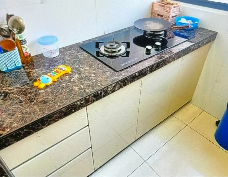 Kitchen features: black marble countertop, built-in gas stove with two burners, cream cabinetry with flat-panel doors, ceramic tile flooring, blue trash bin, plastic storage containers, kitchen utensils, colorful toy on countertop; style: modern.