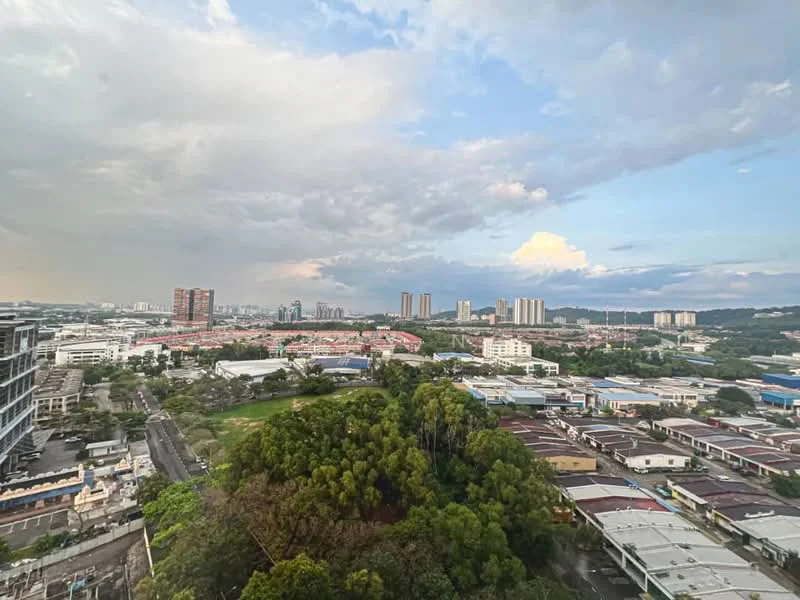 Exterior type: high-rise condominium; features: city skyline view, surrounded by greenery, urban landscape, multiple high-rise buildings, industrial area visible, cloudy sky, open view, roadway visible; style: modern.