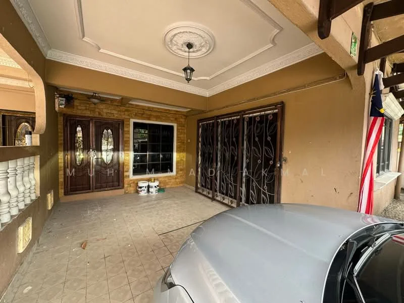 Exterior type: semi-detached house; features: double wooden doors with decorative glass panels, stone cladding on walls, decorative ceiling with crown moulding, outdoor lighting fixture, tiled flooring, security grilles on windows, Malaysian flag displayed, car porch with space for vehicle, manicured landscaping visible, exterior wall painted in beige; style: modern.