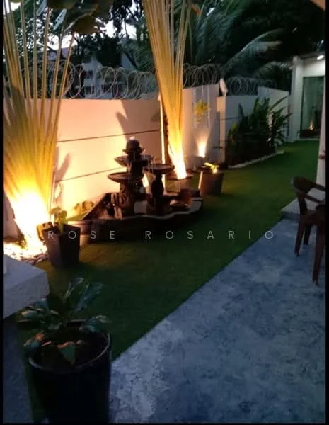 Exterior type: landscape garden; features: artificial grass lawn, decorative stone pathway, water fountain feature, potted plants, outdoor lighting, fenced perimeter, tropical landscaping, wall-mounted lighting fixtures; style: modern.