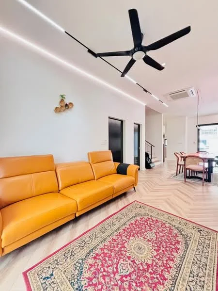 Living features: 3-seater leather sofa in orange, area rug with floral pattern, ceiling fan with integrated LED light, recessed LED strip lighting, wooden flooring, wall-mounted air conditioning unit, decorative wall art, dining table with chairs visible in background; style: modern.