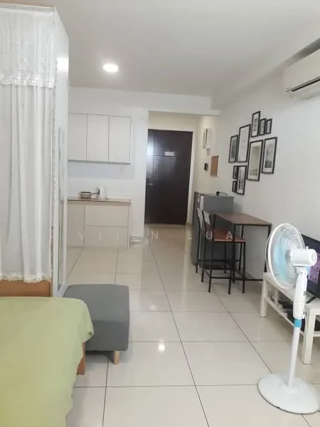 Room features: white painted walls, glossy tile flooring, recessed downlights, wall-mounted split AC, single bed with green bedding, grey ottoman, wooden dining table with two chairs, framed wall art, kitchenette with white cabinets, countertop with kettle, open layout, fan, doorway leading to hallway; style: modern.