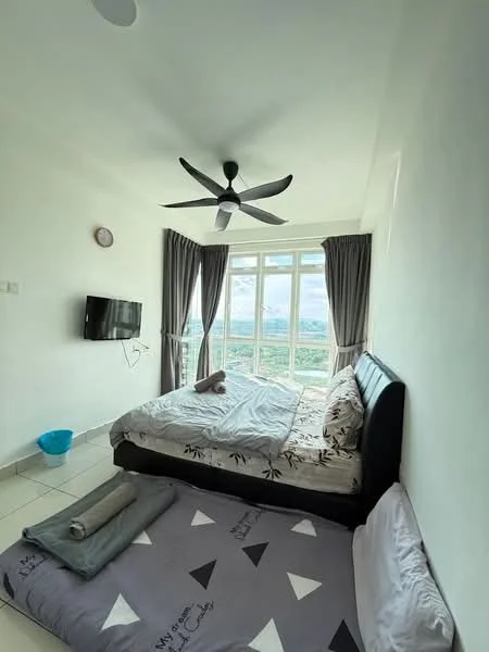 Bedroom features: queen-size bed with black upholstered headboard, white bedding with black floral pattern, 2 pillows, floor-to-ceiling windows, grey curtains, wall-mounted flat-screen TV, ceiling fan with 5 blades, light-colored tiled flooring, decorative wall clock, blue plastic bucket, area rug with geometric pattern; style: modern; view: city.