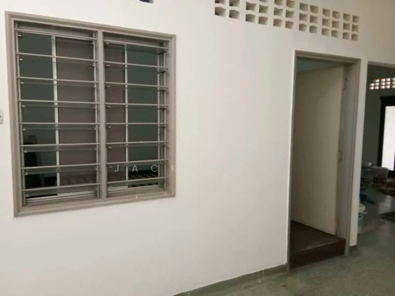 Room features: white painted walls, grey flooring, window with metal grille, doorway leading to another room, small wall ventilation, light switch, no visible furniture or decor; style: minimalist.