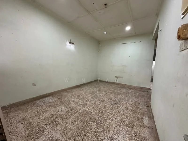 Room features: green painted walls, exposed ceiling, concrete flooring, wall-mounted light fixture, no visible furniture, empty space.