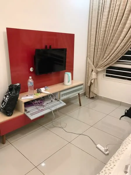 Living features: red accent wall, flat-screen TV mounted on wall, light wood TV console, white kettle, water bottle, power strip on floor, ceramic tile flooring, curtains, window with horizontal slats; style: modern.