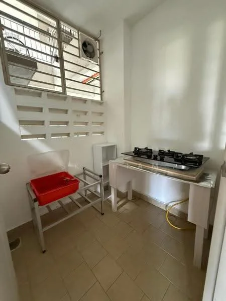 Room features: white painted walls, tile flooring, 4-burner gas hob, stainless-steel countertop, red plastic sink, metal drying rack, window with security grille, exposed plumbing, wall-mounted split AC; style: modern.
